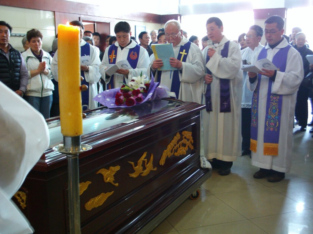 Clergy pray beside body of Shanghai Bishop Joseph Fan Zhongliang