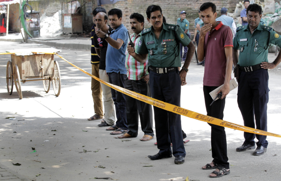 Dhaka police detectives cordon of the scene of the shooting on Monday night