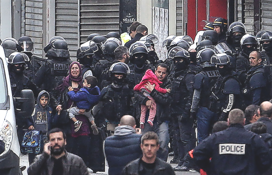 French police evacuate frightened families from their homes in the Paris suburb of St Denis after surrounding a property housing suspected terrorists
