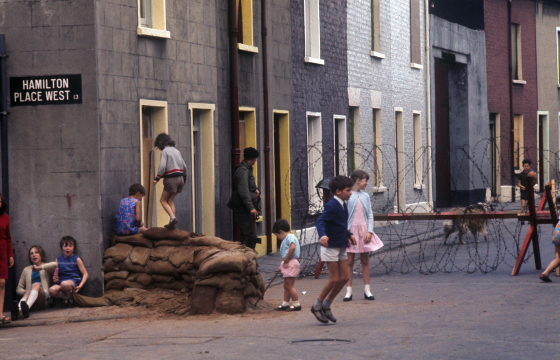 Children play in front of barricades in Belfast during the Troubles