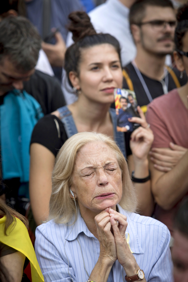 A woman prays during demos in Catalonia
