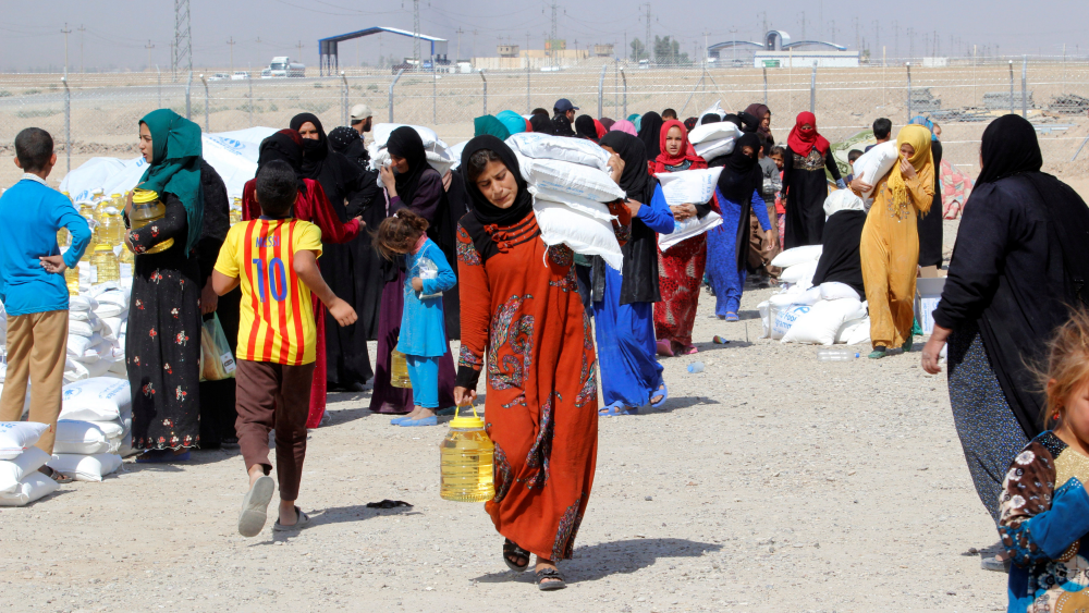 Refugees who fled from Islamic State receive aid in a camp in Daquq, in Iraq. Charities fear a humanitarian crisis is developing after the UN estimated that up to 13 million people may flee the fighting