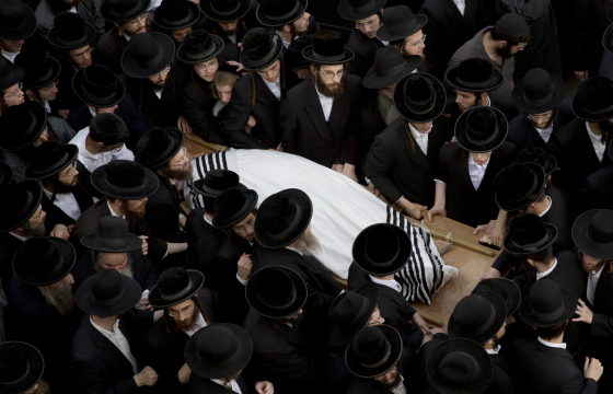 Ultra-Orthodox Jewish men at the funeral of one of the victims of a bus attack in Jerusalem that was also a trigger for the violence
