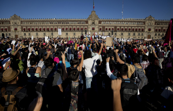 Protestors on the anniversary of the kidnapping of 43 student teachers hold a minute's silence outside the Presidential Palace in Mexico City