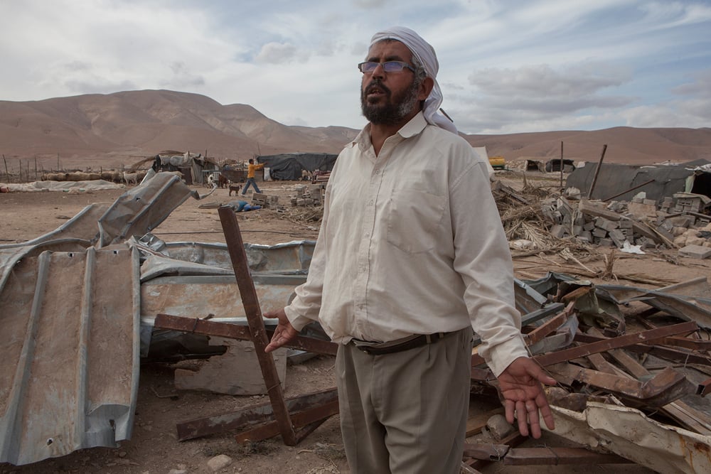 Farmer stands in the ruins of his house Farmer stands in the ruins of his house