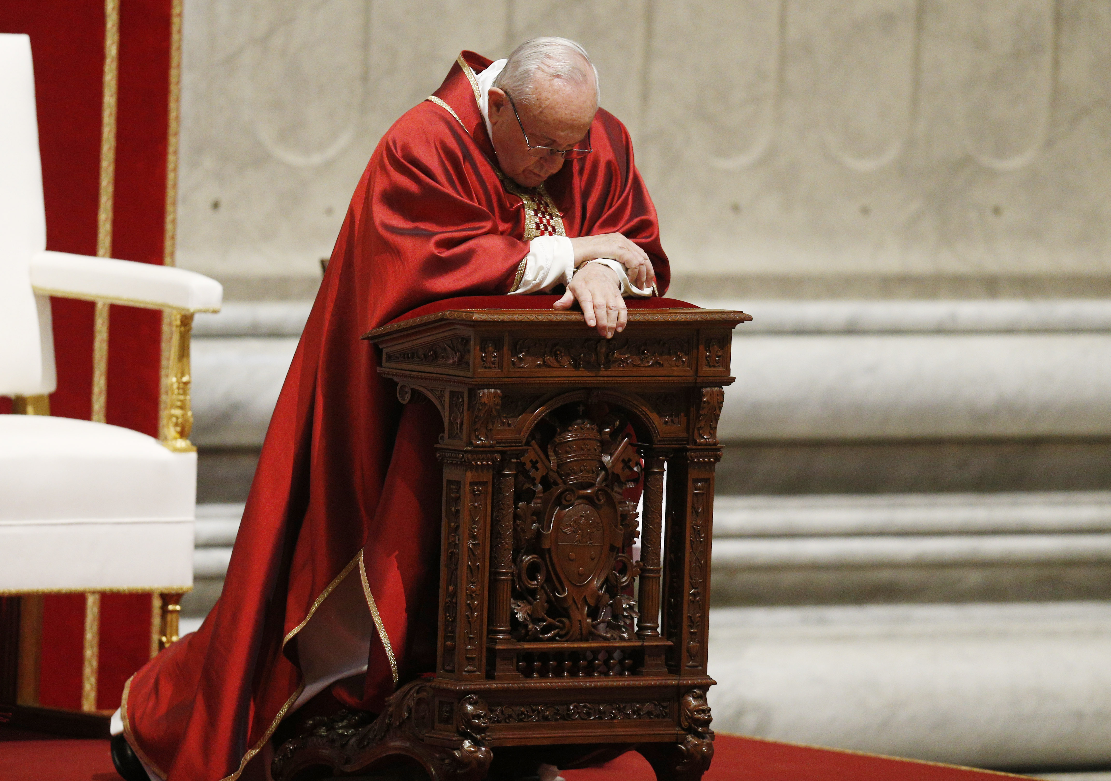 Pope Francis kneels in prayer
