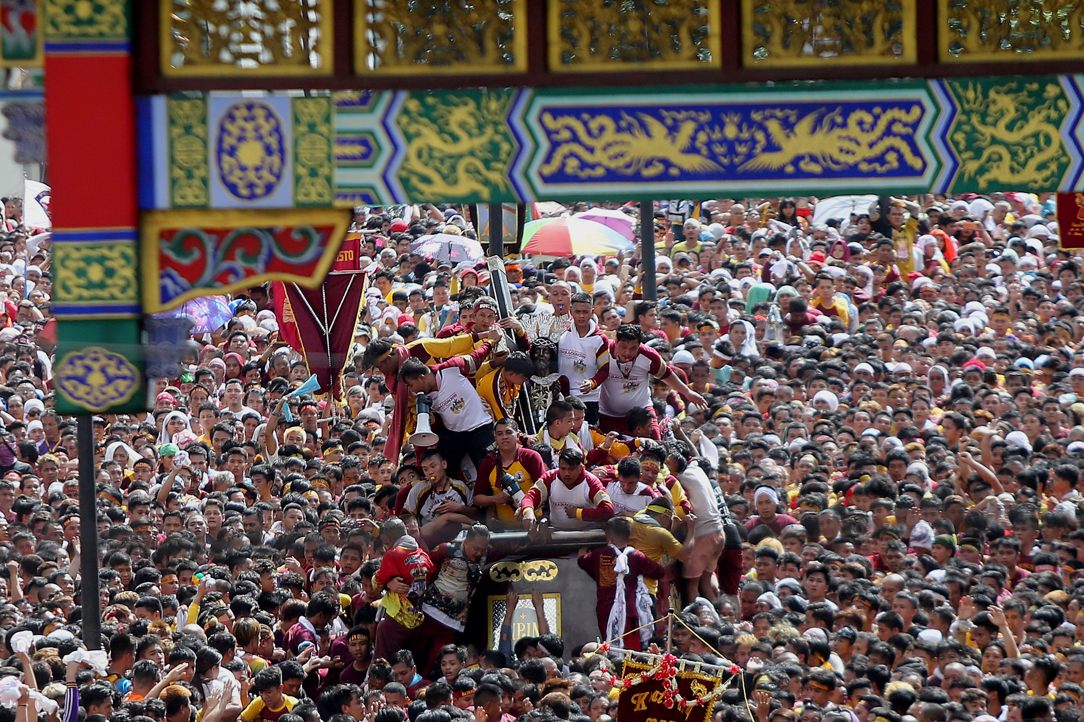Devotees try to touch the life-size statue of the Black Nazarene 